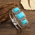 Vintage silver bangle with square turquoise stones and Greek key patterns on wood - Antique Silver Blue Turquoise