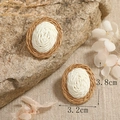 Detail view of woven oval earrings with brown and beige straw texture and 3.8cm size - Tan And Off-White