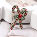 Dettaglio della spilla a bastoncino di Natale con strass rossi e verdi su base oro - Oro Antico Rosso + Verde