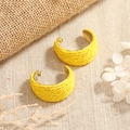 Detail view of bright yellow woven C-shaped earrings with gold metal base on beige fabric - Yellow