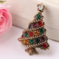 Macro di una spilla a forma di albero di Natale vintage dorata con strass colorati su velluto - Oro KC Antico