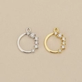 Detailed view of circular gold and silver pendants with sparkling cubic zirconia inlay - Gold / Left Stone