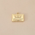 Primer plano de un colgante de casete retro bañado en oro 18k con circonitas - Dorado