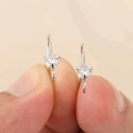 Detailopname van ronde zirkonia oorbellen met vierklauwszetting en gouden afwerking - Zilver