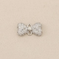 Macro detail of a silver bow pendant with micro-pave cubic zirconia for DIY jewelry - Silver