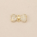 Macro detail of gold-plated bow charm with micro-pave cubic zirconia and double loops - Gold
