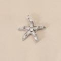 Macro view of silver starfish pendant with clear zircon inlay and fine metal texture - Starfish Style (PJ0258) / Silver