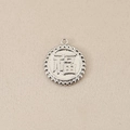 Macro shot of silver Fu character pendant with beaded edge on beige fabric background - With Pattern / Silver