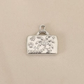 Macro view of silver suitcase pendant with palm tree relief and sparkling zircon inlay - Silver