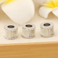 Macro shot of silver jewelry charms with white enamel inlay and micro-pave crystals - Cylindrical Letter H Silver Style / Silver