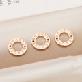 Trois perles donut en plaqué or 18K avec gravure BEAUTY sur un fond de soie brillant - Or rose