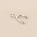 Polished silver wishbone shaped pendant on beige fabric background for jewelry making - Silver