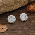 Vintage runde weiße Türkis-Ohrstecker mit silbernem Rand auf rustikalem Holzhintergrund - Weißer Stein Antik Silber