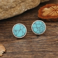 Vintage runde blaue Türkis-Ohrstecker in Silberfassung auf einem Holzhintergrund - Türkis Antik Silber