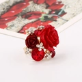 Macro detail of 3D resin roses and red gemstones on an ornate gold plated adjustable ring - Red