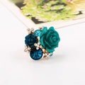 Detalle de anillo rosa de resina con cristales azules y pedrería en banda dorada - Azul lago