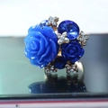 Macro detail of blue resin rose ring with navy crystals and gold metal accents - Sapphire Blue