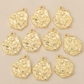 Macro detail of 10 gold plated floral pendants with cubic zirconia on beige silk - Matte Plant Embossed Style / Gold Style 2