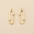 Detailed macro view of 18k gold plated safety pin pendant with zircon and spiral twist design - Left / Gold