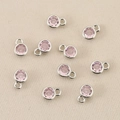Makroaufnahme von 10 rosa Zirkonia-Anhängern in Silberfassung für DIY-Schmuckherstellung - Silber-Rosa