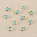 Detailed view of ten 18k gold plated round pendants with light blue zircon for DIY jewelry - 3mm / Gold Turquoise