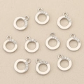 Detailed view of silver plated pendants with cubic zirconia inlay on textured fabric - Silver Round Geometric (Style 3)
