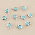 Detailansicht von zehn hellblauen runden Geburtsstein-Anhängern für DIY-Schmuck - Silber Türkis