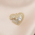 Macro detail of gold-plated heart pendant with pavé cubic zirconia on satin fabric - Gold