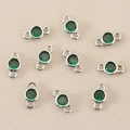 Close-up of circular green zircon pendants with silver plated dual-ring connectors for DIY jewelry - Silver/Green