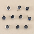 Dettaglio macro di ciondoli con pietre natali blu scuro e montatura circolare in metallo argento - Argento Blu Reale