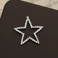 Macro detail of star-shaped 18K gold-plated pendant with micro-pave white cubic zirconia - Silver