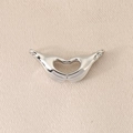 Close-up of heart-shaped hands pendant in polished silver finish for DIY jewelry - Silver