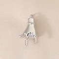 Close-up of polished silver metal hand gesture pendant on beige silk background - Rock Gesture Style (PJ0126) / Silver