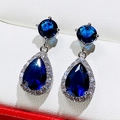 Sparkling silver bow earrings with pear-cut deep blue sapphire and zircon halo crystals - Blue Zirconia