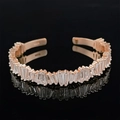 Minimalist rose gold open bangle with baguette-cut pavé zircons on black background - Rose Gold Eternity Style