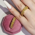 Detailed close-up of two eternity bands featuring square yellow stones in gold plating - US 5 / Gold