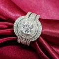 Luxurious silver three-piece bridal set with halo round cut stone on red silk background - US 5 / Main Ring with Two Bands