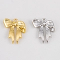 Close-up of gold and silver bow-knot metal charms for DIY jewelry making and crafts - Ribbon Bow / Silver