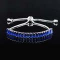 Adjustable silver bracelet featuring rectangular-cut deep blue gemstones on black background - Blue