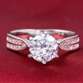 Macro shot of silver six-prong engagement ring with round cubic zirconia on red velvet - US 5 / Silver