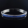 Polished silver bracelet with rectangular blue baguette gemstones on a black background - Silver Blue Gemstone Style