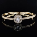 Elegant gold open bangle with a central round stone and paved diamond accents - Gold Halo Solitaire Style