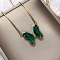 Elegant gold butterfly necklace with emerald green crystal wings in a luxury jewelry box - Green