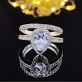 Luxuriöses silbernes Ring-Set mit birnenförmigem Zirkonia auf schwarzer reflektierender Oberfläche - Größe 5 / Birnen-Halo-Dreiteiliges Set (R603-R4211a)