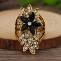 Vista macro de anillo de flor vintage dorado con gemas negras y diamantes de imitación - Negro Oro Antiguo