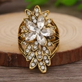 Makroaufnahme eines Vintage-Goldrings mit Marquise-Strasssteinen auf Holzsockel - Antikgold mit Weißem Strass