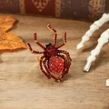 Primer plano del anillo de araña dorado con cristales rojos sobre fondo Halloween - Rojo y Rojo Oscuro Oro Antiguo