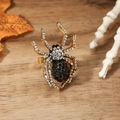 Detalle de un anillo de araña vintage con cristales negros y blancos en banda dorada - Negro y Blanco Oro Antiguo