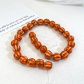 Close-up of pumpkin-shaped striped ceramic beads in orange-brown for DIY jewelry making - Orange