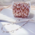 Close-up of pink pearl and faceted crystal bead chain on a gold reel for DIY jewelry - 0.5 Meters/Pack / White